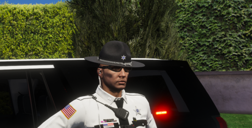 Could contain: outdoor, person, tree, fashion accessory, man, hat, clothing, sun hat, fedora, car, land vehicle, human face, vehicle, grass, wearing, driving