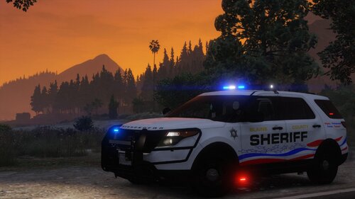 Could contain: vehicle, land vehicle, transport, outdoor, wheel, tire, police car, emergency service, law enforcement, sport utility vehicle, ford, police, emergency vehicle, tree, text, road, mountain, sunset, driving, car